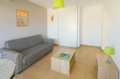 a living room with a couch and a coffee table at Mini villa vue mer et wifi dans petite résidence avec piscine chauffée in Serra-di-Ferro