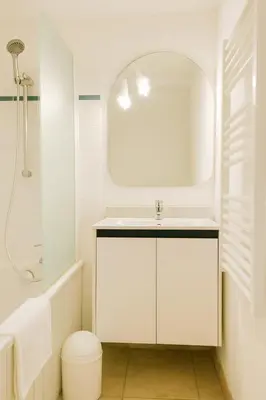 a white bathroom with a sink and a mirror at Mini villa vue mer et wifi dans petite résidence avec piscine chauffée in Serra-di-Ferro