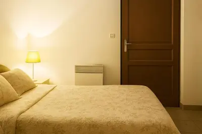 a bedroom with a large bed and a door at Mini villa vue mer et wifi dans petite résidence avec piscine chauffée in Serra-di-Ferro