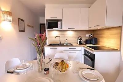 a kitchen with a table with a bowl of food on it at Cala di Sole - T2 Cabine, Piscine & Plage in Pianottoli-Caldarello