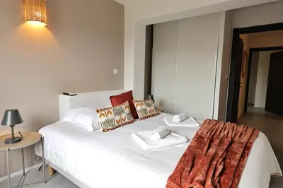 a bedroom with a large white bed with pillows at Cala di Sole - T2 Cabine, Piscine & Plage in Pianottoli-Caldarello