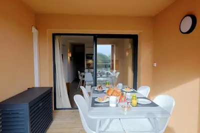 a table with a plate of food on it at Cala di Sole - T2 Cabine, Piscine & Plage in Pianottoli-Caldarello