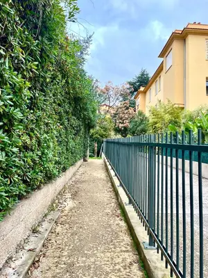 a fence next to a sidewalk next to a building at Appartement hyper centre 100m de la plage in Ajaccio