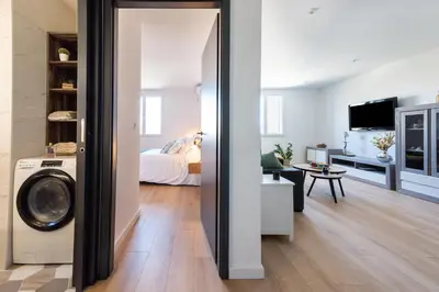 a bedroom with a bed and a washing machine in a room at Nebbiu - 25km de Bastia in Murato