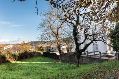 a grassy yard with a house and a fence at Nebbiu - 25km de Bastia in Murato