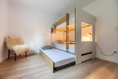 a small room with a bunk bed and a chair at Nebbiu - 25km de Bastia in Murato