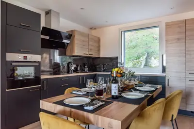 a kitchen with a wooden table with chairs around it at Nebbiu - 25km de Bastia in Murato