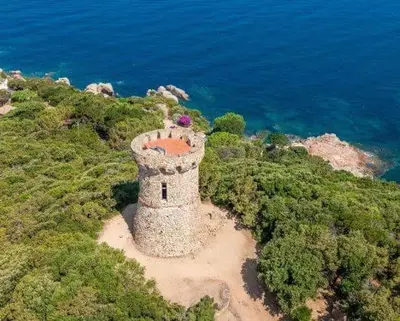 an aerial view of a stone building on a hill next to the ocean at L'Onda Serena - 4 couchages à 5 min de la plage in Ajaccio