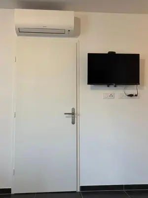 a white door with a television on top of it at L'Onda Serena - 4 couchages à 5 min de la plage in Ajaccio