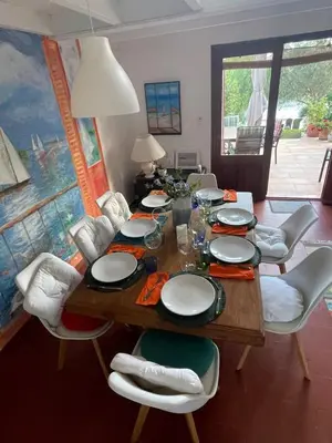 a dining room with a wooden table and white chairs at San Ciprianu-Lecci House, seaside, beach 2'' in Lecci