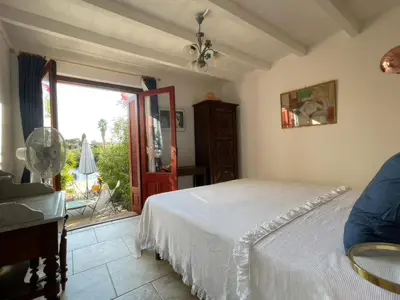 a bedroom with a bed and a sliding glass door at San Ciprianu-Lecci House, seaside, beach 2'' in Lecci