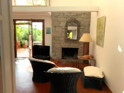 a living room with two chairs and a fireplace at San Ciprianu-Lecci House, seaside, beach 2'' in Lecci