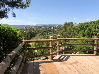 a wooden boardwalk with a view of a valley at Villa Santa Giulia, vue mer, plage à pieds in Porto-Vecchio
