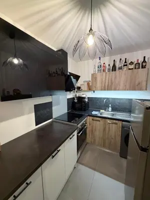 a kitchen with white cabinets and black counter tops at Grand Studio Neuf in Ajaccio
