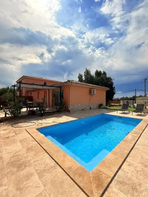 a villa with a swimming pool in front of a house at Villa Paraìso, maison avec piscine route de Calenzana in Calenzana