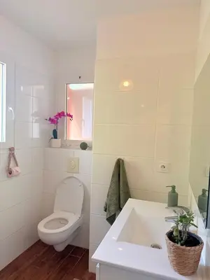 a white bathroom with a toilet and a sink at Villa Paraìso, maison avec piscine route de Calenzana in Calenzana