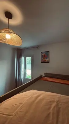 a bedroom with a large bed and a light at Villa Paraìso, maison avec piscine route de Calenzana in Calenzana