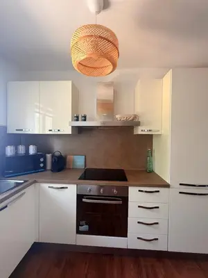 a kitchen with white cabinets and aendant light at Villa Paraìso, maison avec piscine route de Calenzana in Calenzana