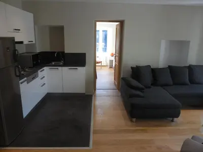a living room with a couch and a kitchen at Saint Christophe in Omessa