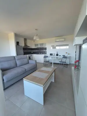 a living room with a couch and a kitchen at T2 vue mer in Chiatra