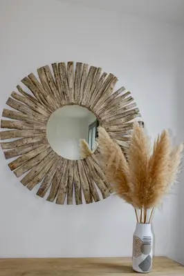 a mirror on a wall with a vase with feathers at Les Hauts du Port - T2 Moderne et chaleureux in Bonifacio