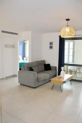 a living room with a couch and a table at Les Hauts du Port - T2 Moderne et chaleureux in Bonifacio