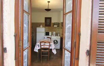 a kitchen with a table and a washing machine at Gorgeous Home In Valle Di Rostino in Valle-di-Rostino