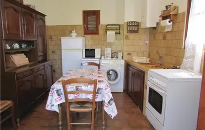 a kitchen with a table with chairs and a washing machine at Gorgeous Home In Valle Di Rostino in Valle-di-Rostino