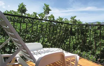 a white chair on a balcony with a view of trees at Gorgeous Home In Valle Di Rostino in Valle-di-Rostino