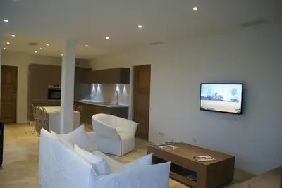 a living room with a couch and a tv on a wall at A Casa Nèra in Porto Pollo