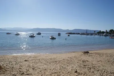 a beach with boats in a body of water at A Casa Nèra in Porto Pollo