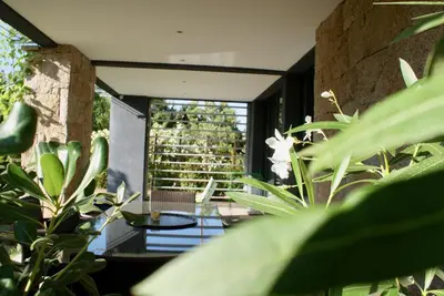 a room with a glass table and some plants at A Casa Nèra in Porto Pollo
