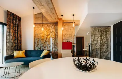 a living room with a white table and a blue couch at Citta di Lume Suites & Lofts in Porto-Vecchio