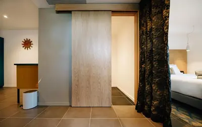 a room with a bed and a door with a curtain at Citta di Lume Suites & Lofts in Porto-Vecchio