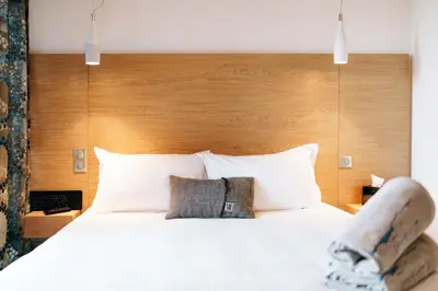 a person sitting on a bed in a hotel room at Citta di Lume Suites & Lofts in Porto-Vecchio