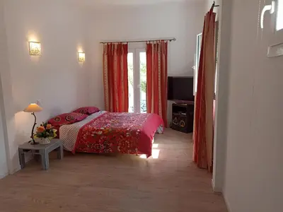 a bedroom with a bed and a television in it at Villa avec piscine et belle vue mer proche des plages et commerces in Porticcio