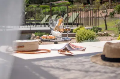 a table with a plate of food and glasses of wine at Résidence Casarina in Bonifacio
