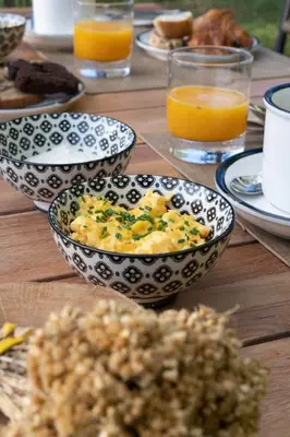 a wooden table with plates of food and glasses of orange juice at Résidence Casarina in Bonifacio