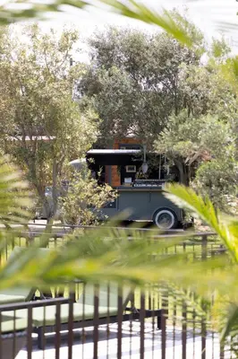an old car parked in a park with trees at Résidence Casarina in Bonifacio