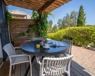 a table and chairs sitting on a wooden deck at Résidence Casarina in Bonifacio