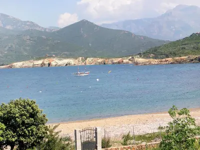 a boat in the water on a beach with mountains at Villa Fidiamare by Interhome in Galeria