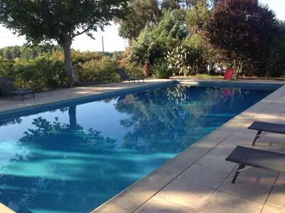a swimming pool with blue water and two benches at U-Casone in Linguizzetta