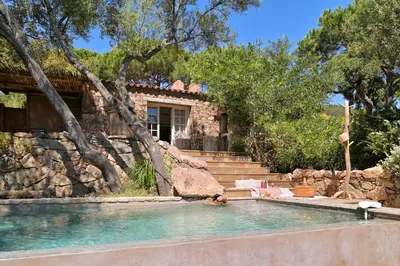a pool in front of a house with trees at Domaine Les Oliviers de Palombaggia in Porto-Vecchio