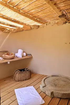 a room with a shelf with towels and a rug at Domaine Les Oliviers de Palombaggia in Porto-Vecchio