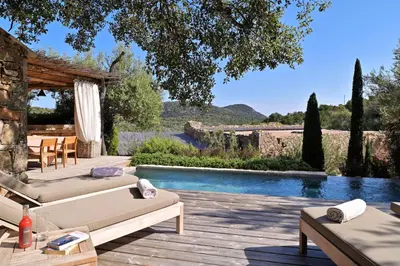a patio with two beds and a swimming pool at Domaine Les Oliviers de Palombaggia in Porto-Vecchio