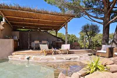 a backyard with a pool with chairs and a pergola at Domaine Les Oliviers de Palombaggia in Porto-Vecchio