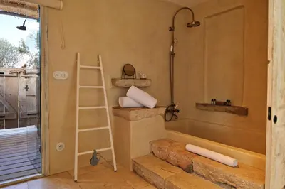 a bathroom with a bath tub and a ladder at Domaine Les Oliviers de Palombaggia in Porto-Vecchio