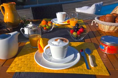 a table with a cup of coffee and fruit on it at Chambres d'hôtes Casa di l'Oru in Porto-Vecchio