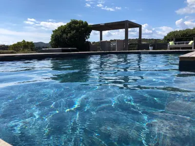 a large swimming pool with a gazebo at Chambres d'hôtes Casa di l'Oru in Porto-Vecchio