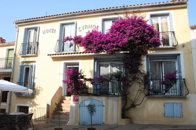 a building with purple flowers on the side of it at Hotel Cyrnos in Cargèse